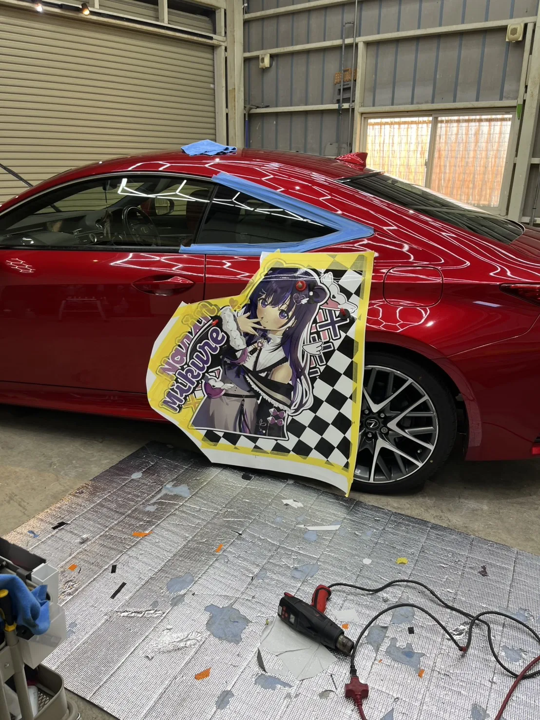 印刷したキャラクターのシートを、ドアに合わせて位置決めしている