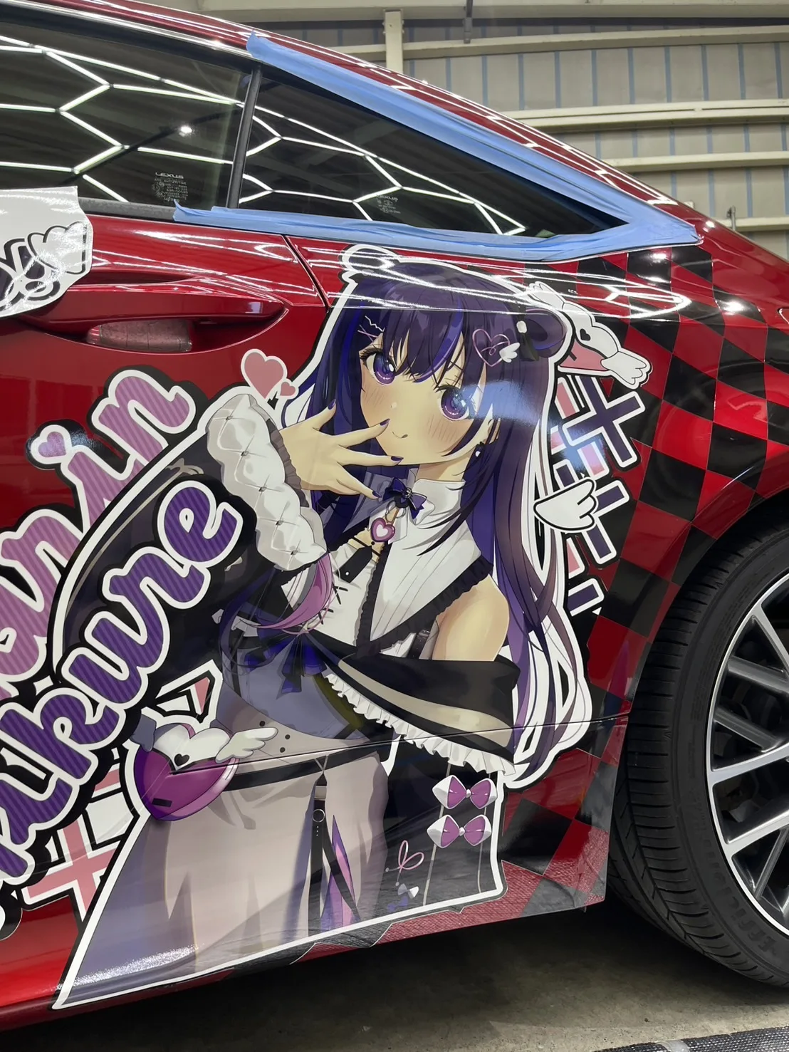 赤いレクサスのドアに、キャラクターの柄を貼り込んだ痛車